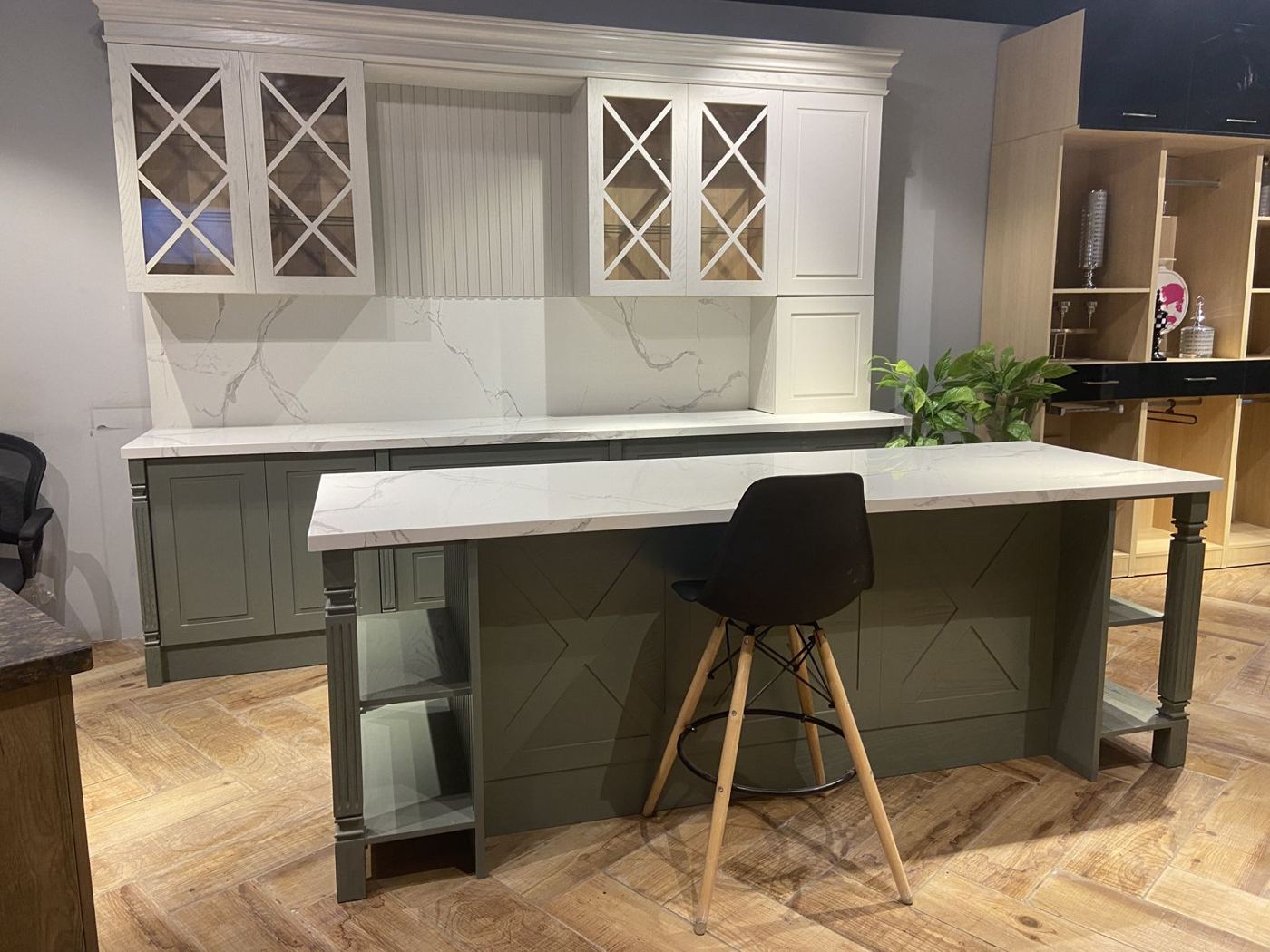 Sage green kitchen with island on display in our Center Ville showroom