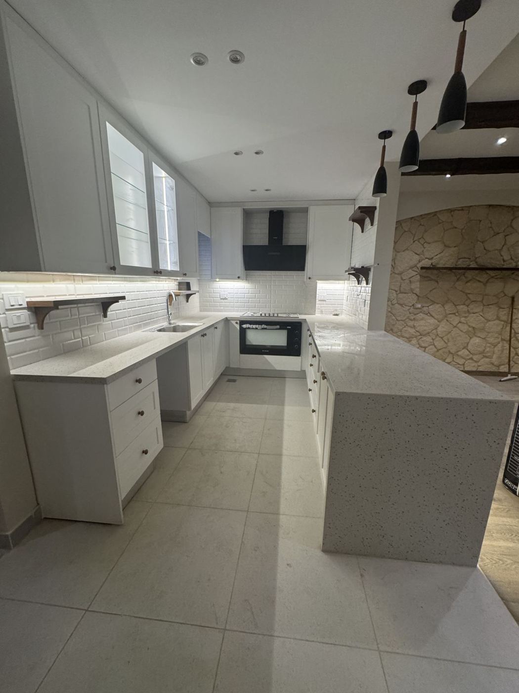 White U-shaped kitchen with stone peninsula