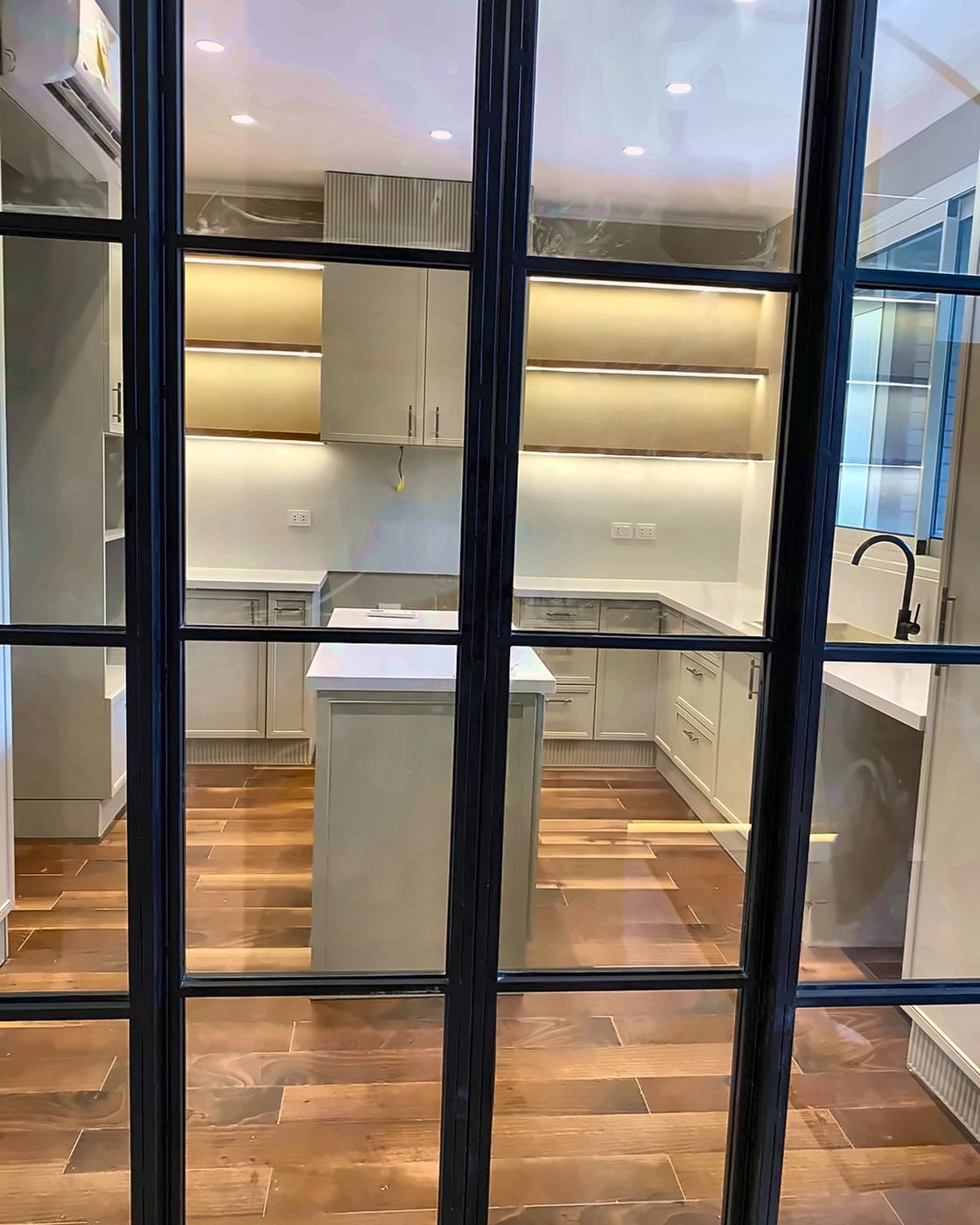 Kitchen seen through black steel glass doors, New Giza